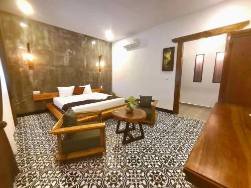 a hotel room with a bed and a table at Villa Romduol in Kampot