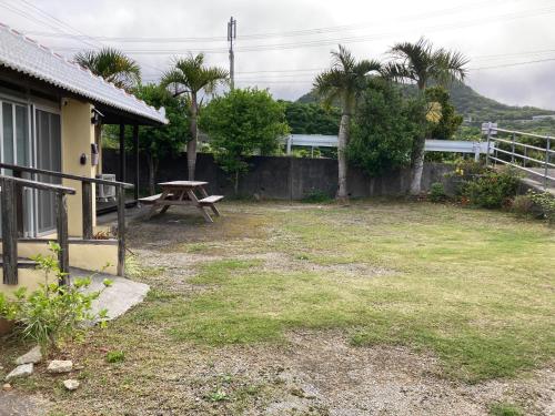 a picnic table in a yard next to a house at たーちやー in Motobu