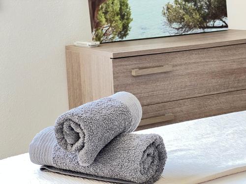 a towel sitting on a bed in front of a dresser at Moderno appartamento dí Beniamino Murgioni a Villasimius in Villasimius