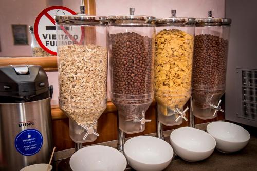 a group of four glass containers filled with cereal at Hotel Emmaus in Rome