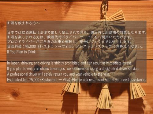 a sign on a wooden wall with writing on it at Azumino Salon in Azumino