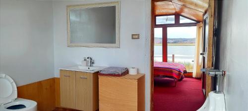 a bathroom with a sink and a bed and a window at Los uros Jakana Lodge in Puno