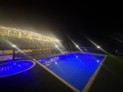 a swimming pool at night with lights at Glamping Mirador El Tunel in Estación El Salto