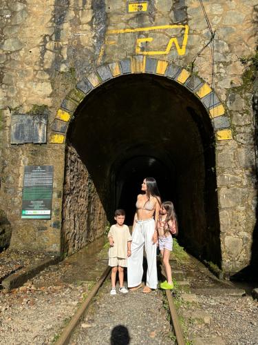 a woman and two children standing in a tunnel at Glamping Mirador El Tunel in Estación El Salto