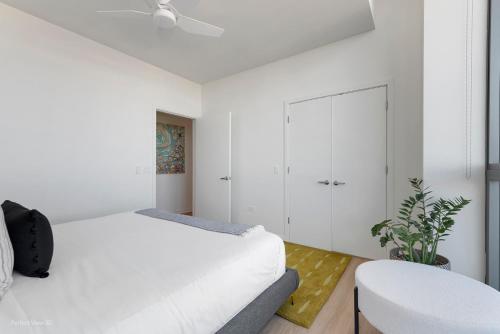 a white bedroom with a bed and a white cabinet at K2 Sky High Apartments with Stunning Chicago Views in West Loop in Chicago
