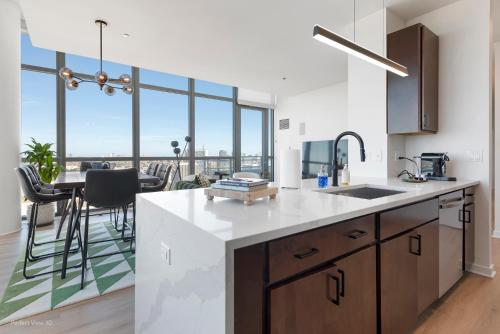 a kitchen with a counter and a table with a view at K2 Sky High Apartments with Stunning Chicago Views in West Loop in Chicago