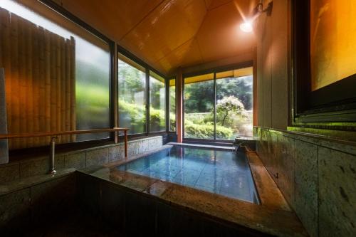 a hot tub in a room with a window at Jizaiso in Nasu