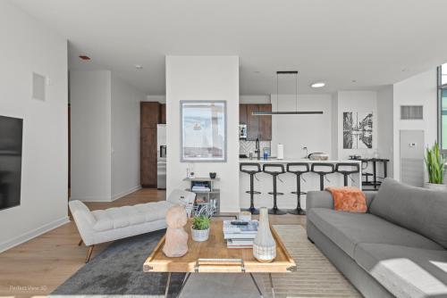 a living room with a couch and a table at K2 Sky High Apartments with Stunning Chicago Views in West Loop in Chicago