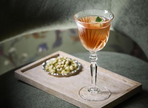 a drink in a glass on a cutting board with a bowl of food at The St. Regis Shenzhen Bao'an in Shenzhen