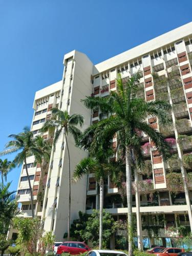 a tall building with palm trees in front of it at Mentari View Homestay in Port Dickson