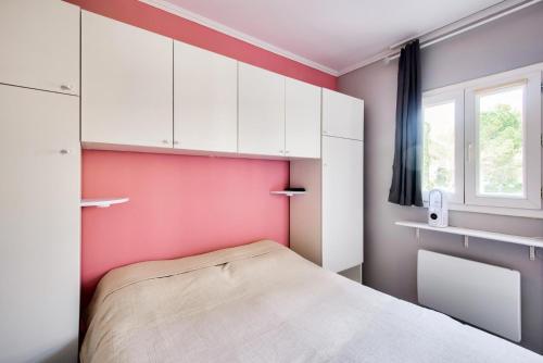- une petite chambre avec des murs roses et un lit dans l'établissement Village Pont Royal en Provence - maeva Home - Appartement 2 Pièces 5 Personnes - Sélection - super Home MAE-1242, à Mallemort