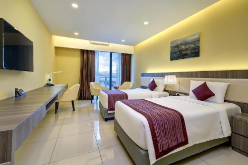 a hotel room with two beds and a desk at Sky Retreat Genting Highlands in Genting Highlands