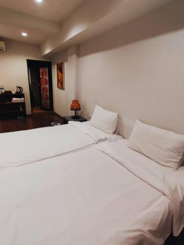 a bedroom with a large white bed with white pillows at mstay in Bangkok