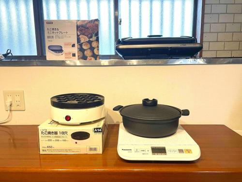 a slow cooker sitting on top of a box on a counter at 御宿ゲストハウス 海おやぶん in Onjuku