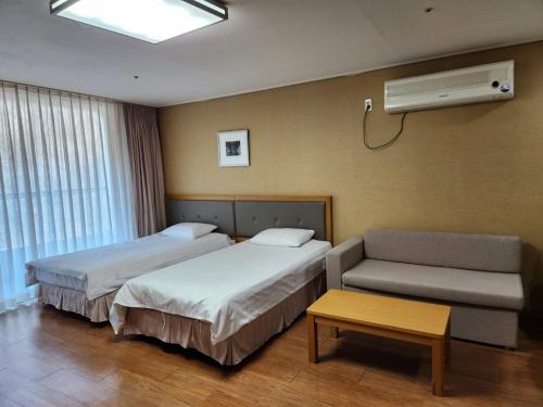a hotel room with two beds and a couch at Jeongseon Mayhills Resort in Jeongseon