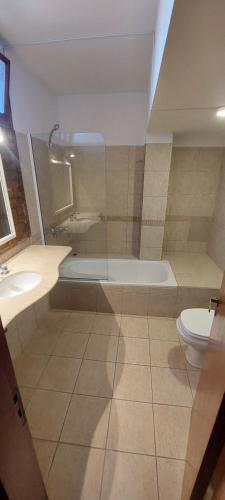 a bathroom with a tub and a toilet and a sink at Hotel Salto Grande in Federación