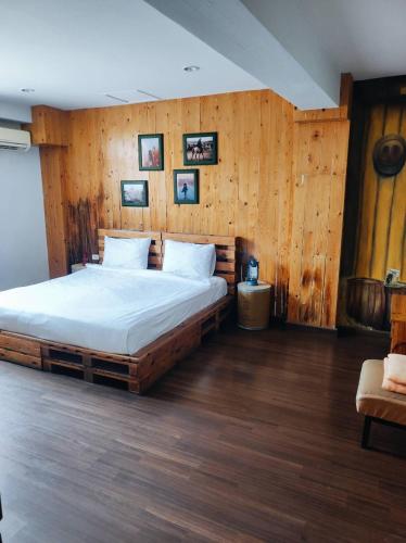 a bedroom with a large bed with wooden walls at mstay in Bangkok