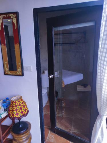 a glass door to a bathroom with a mirror at mstay in Bangkok