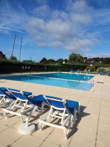 une piscine avec deux chaises et une piscine dans l'établissement Résidence Port du Crouesty - maeva Home - Appartement duplex 2 pièces 7 personnes Confort MAE-9689, à Arzon