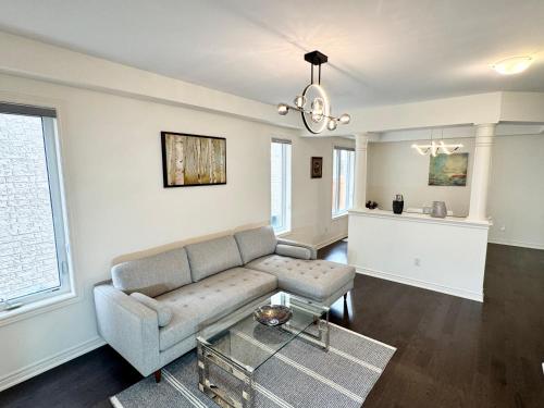 a living room with a couch and a table at Elegant Retreat near Toronto Airport & Downtown in Brampton