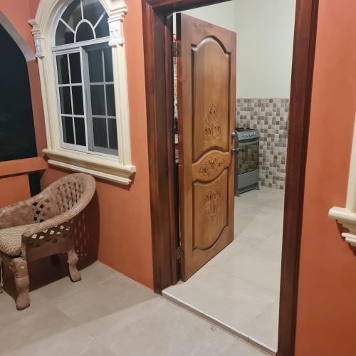 a room with a door and a chair and a mirror at Paradise Place Grande King in Cave Hill