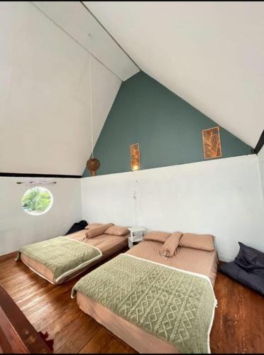 two beds in a room with a attic at Prisma cabin in Batur
