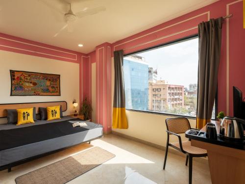 a bedroom with a bed and a large window at The Hosteller Jaipur, MI Road in Jaipur