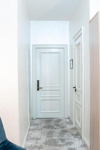 a white door in a white room with a floor at Meros Boutique Hotel in Samarkand