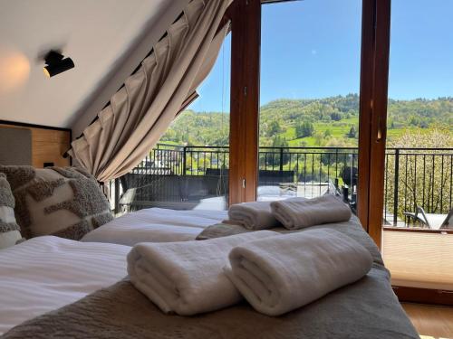 two beds in a room with a large window at Domki Pienińskie Tarasy in Szczawnica