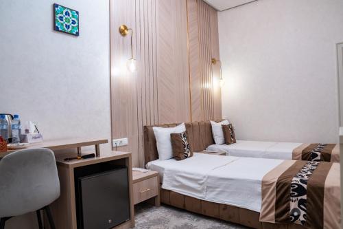 a hotel room with two beds and a tv at Meros Boutique Hotel in Samarkand