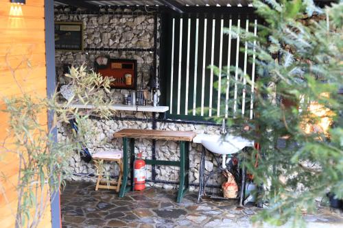 a stone wall with a bench and a table at PAMJA Guest House in Bărăşti
