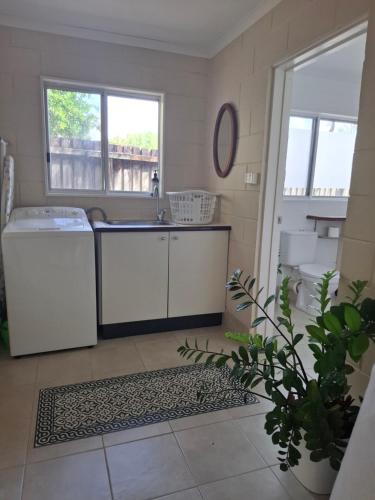 a kitchen with a sink and a washing machine at J & Ella's Holiday House - 1 Bedroom, 1 Bathroom Home in Cooktown