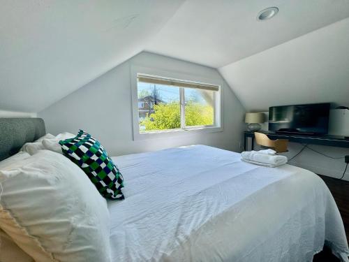 a bedroom with a large white bed with a window at Craftsman with view of Seattle in Seattle