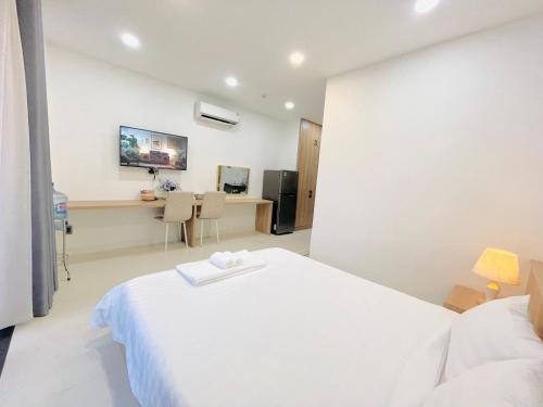a bedroom with a white bed and a desk at 501 Modern Studio with Balcony & Kitchen in Ho Chi Minh City