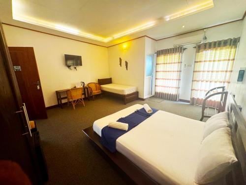 a hotel room with a large bed and a table at Nico Lagoon Hotel in Negombo