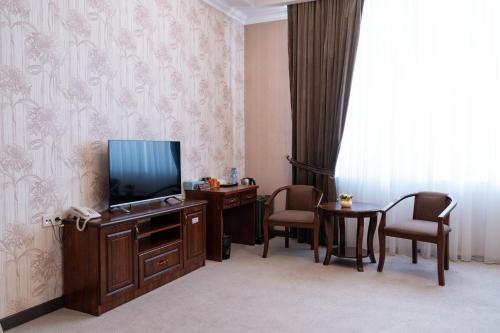 a hotel room with a television and two chairs at Meros Boutique Hotel in Samarkand