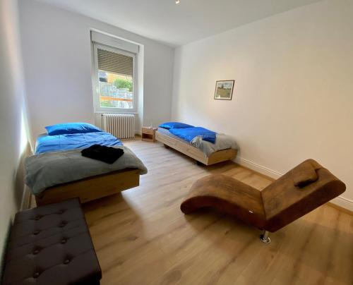 1 Schlafzimmer mit 2 Betten und Holzboden in der Unterkunft Les 2 suites de Belfort 184m2 Centre Parkings in Belfort