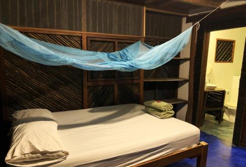 a bedroom with a bed with a hammock above it at Chez Oliv in Palomino