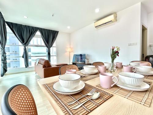 a dining room with a table with cups and chairs at CozyHome 1-10pax Sunway Nexis link IOI mall & MRT in Petaling Jaya