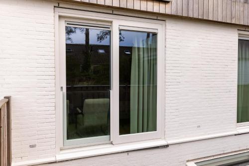 a sliding glass window on a house at VlieMare Appartementen De Kluut in Oost-Vlieland