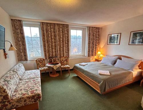 a hotel room with a bed and a couch at Das Muldenschlösschen in Lunzenau