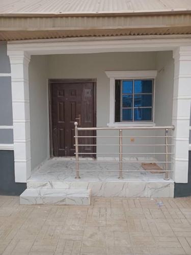 a front porch of a house with a brown door at SAMDET APARTMENTs in Ibadan