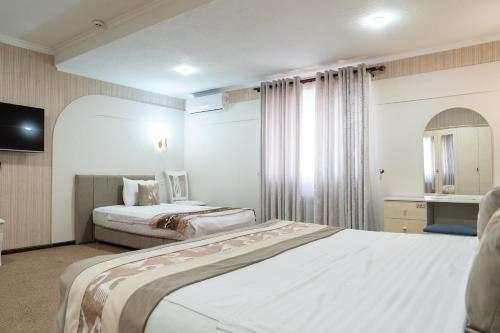 a hotel room with two beds and a television at Meros Boutique Hotel in Samarkand