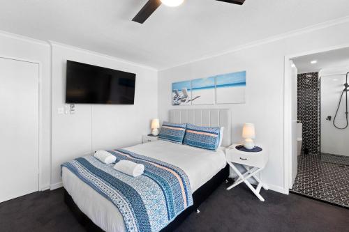 a bedroom with a bed and a tv on the wall at Beach Studio Ocean Views Level 17 Pool Gym Sauna in Gold Coast