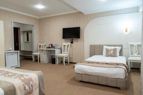 a hotel room with two beds and a flat screen tv at Meros Boutique Hotel in Samarkand