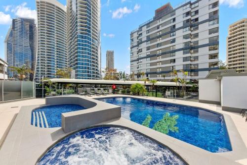 a pool on the roof of a building with tall buildings at Beach Studio Ocean Views Level 17 Pool Gym Sauna in Gold Coast