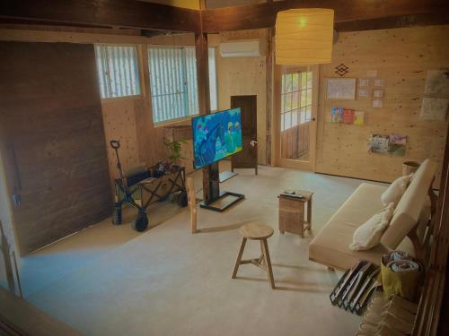 a living room with a tv and a couch at HANARE紡舎Tsumugiya in Ogawa
