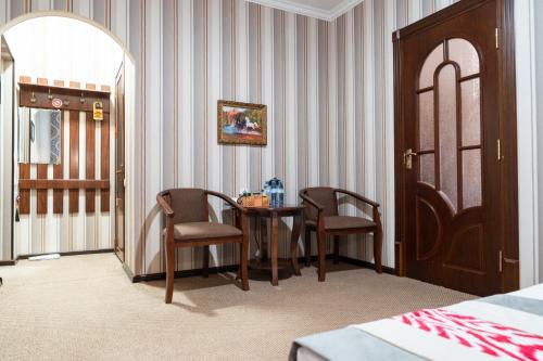 a room with a table and two chairs and a bed at Meros Boutique Hotel in Samarkand