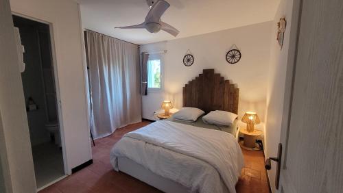 - une chambre avec un lit et 2 réveils sur le mur dans l'établissement Le Clos des Oiseaux YourHostHelper, à Narbonne