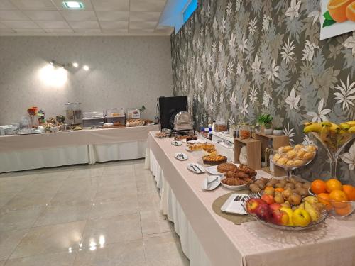 Una línea de buffet con frutas y pasteles. en Hotel Playa Compostela, en Vilagarcía de Arousa